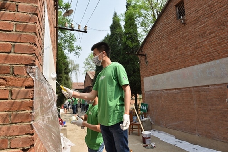 已压缩_有爱爱学生志愿者在粉刷学校的墙壁.jpg